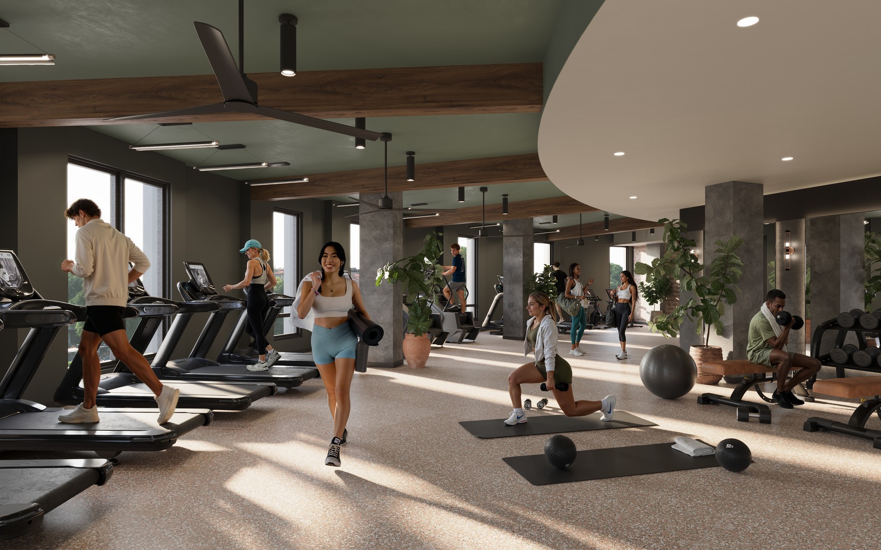 People working out in the modern Rambler Riverfront gym with treadmills, free weights, mats, and exercise balls. Some are running, stretching, or lifting weights. Large windows and plants decorate the bright, spacious room.