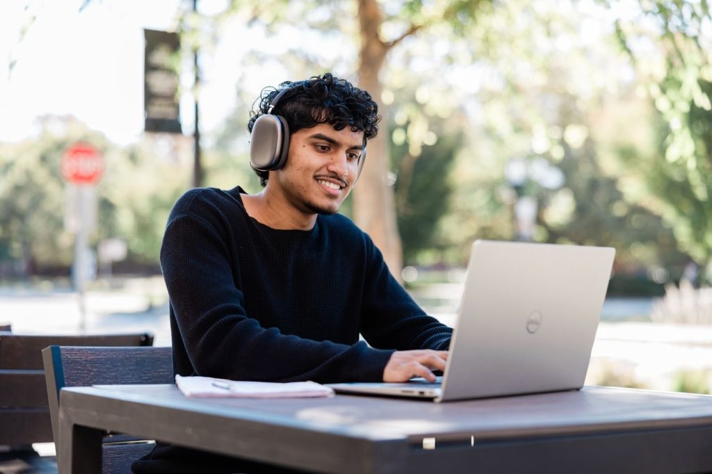A Purdue student sitting and working on a computer, focused on his screen.