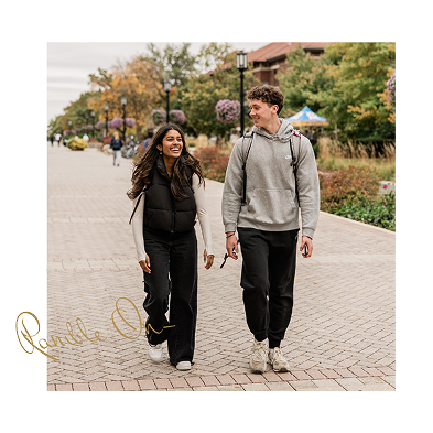 A woman and a man walk side by side on a paved path lined with trees near Purdue off campus housing. Both are smiling in casual clothes, enjoying a stroll outdoors on a cloudy day.