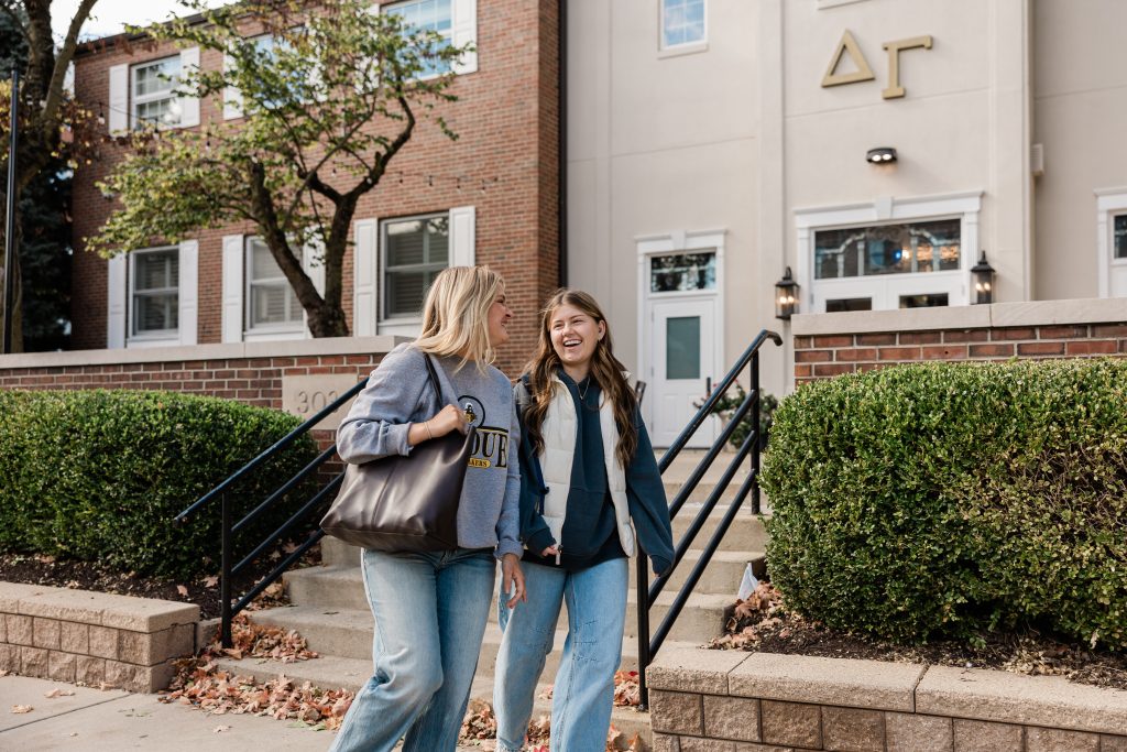 Two Purdue students walking and chatting on Purdue’s campus.