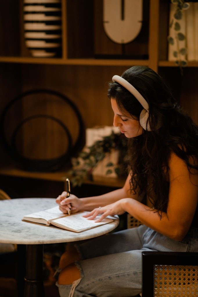 A Purdue student writes in their notebook in an off-campus coffee shop in West Lafayette.