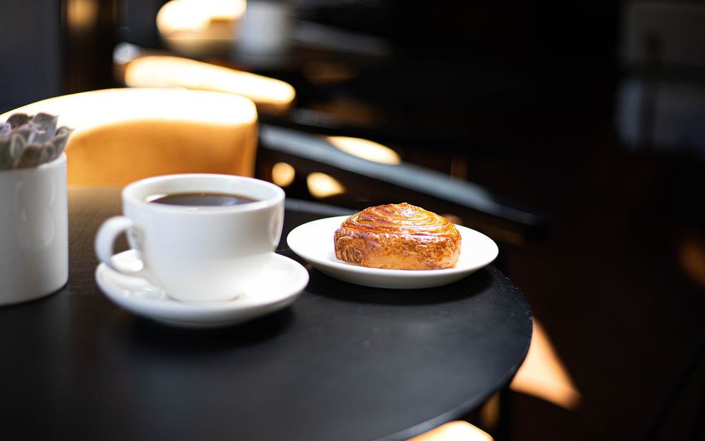 Coffee and a pastry on a table at Leaps Coffee in West Lafayette near Rambler Riverfront.
